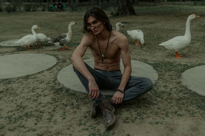 Full length of young man eating bird at water