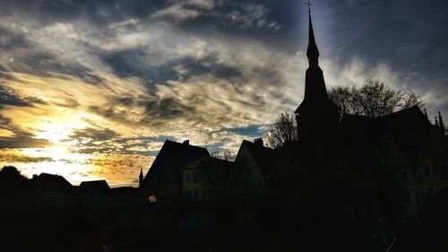 Low angle view of buildings against cloudy sky