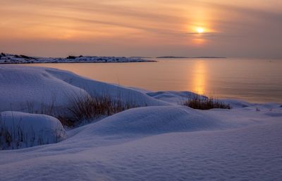 Scenic view of frozen sea against sky during sunset