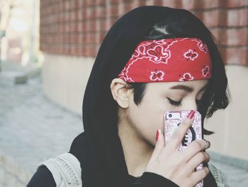 Close-up of young woman holding mobile phone