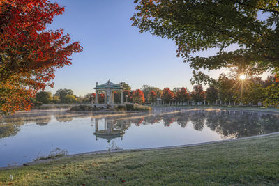 Scenic view of lake by building against sky during autumn