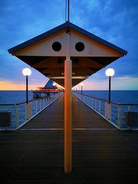 Pier over sea against sky during sunset