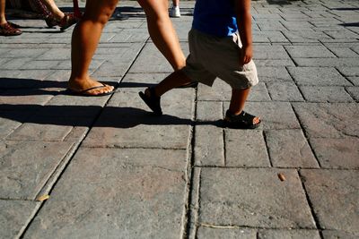 Low section of people walking on sidewalk