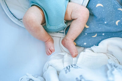 Low section of child sitting on bed