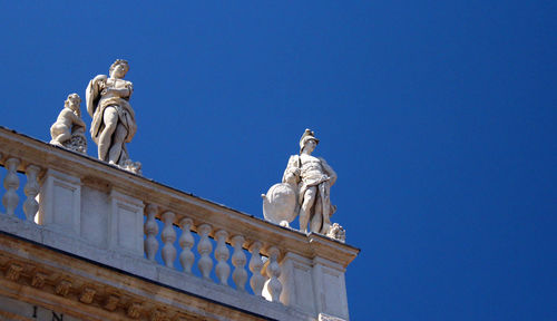 Low angle view of statue against blue sky