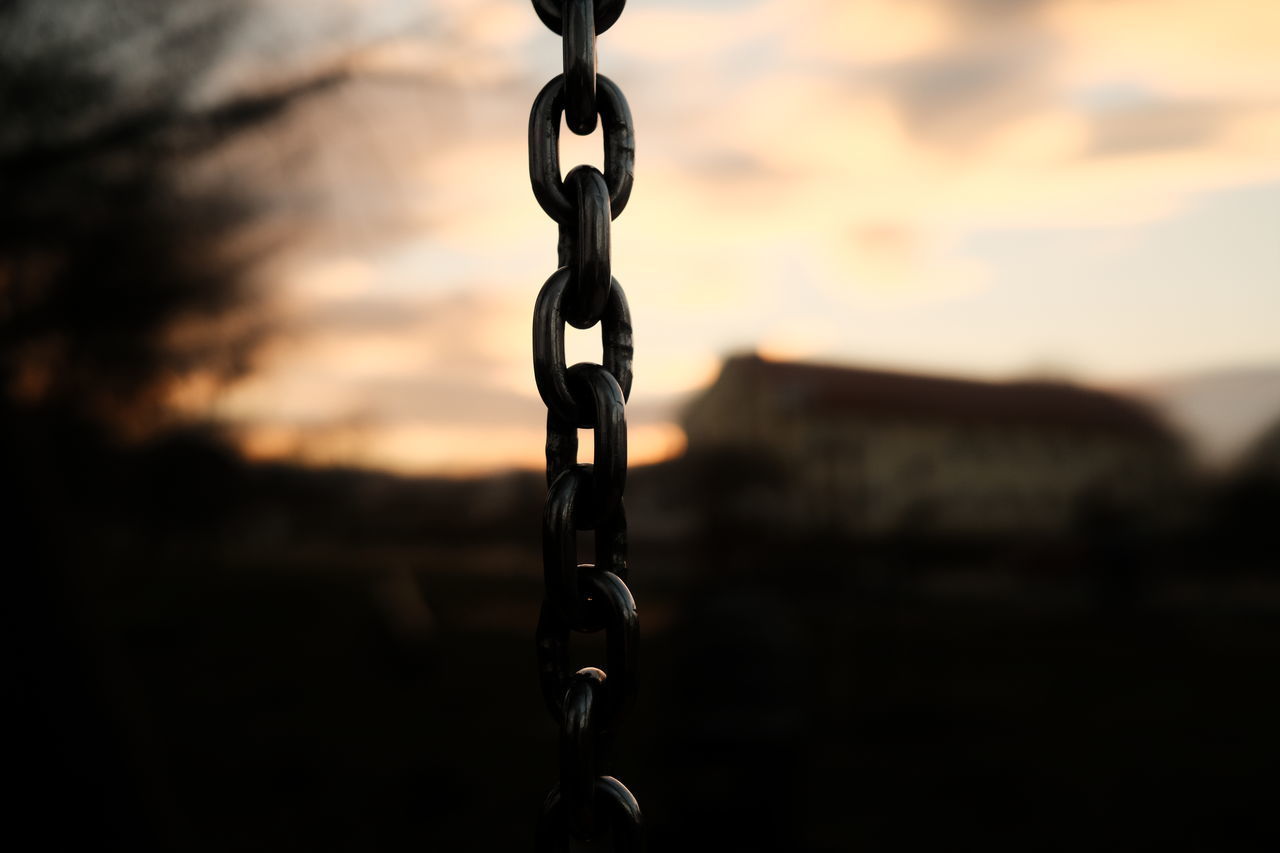 CLOSE-UP OF METAL CHAIN AGAINST SKY