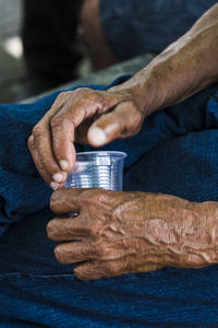 Hands of a person holding a clear plastic cup. city of cachoeira, bahia, brazil.