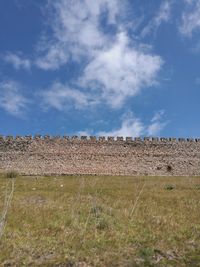 Hay bales on field against sky