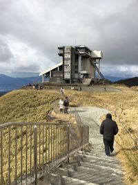 Rear view of man walking on stairs at landscape