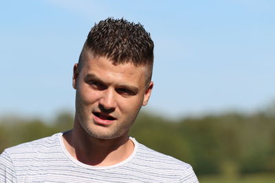 Portrait of young man against clear sky