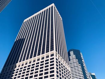 Low angle view of modern buildings against clear blue sky