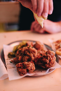 Close-up of hand holding food in plate