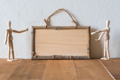 Close-up of wooden figurines with frame on wooden table