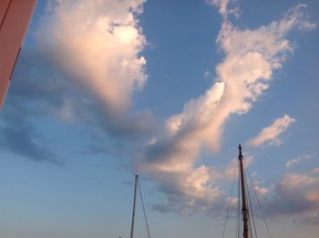 Low angle view of electricity pylon against cloudy sky