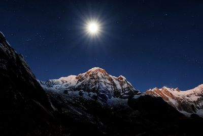 Low angle view of snowcapped mountains against sky