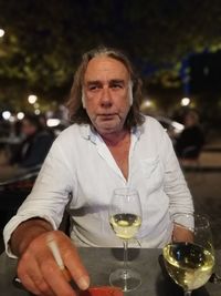 Portrait of man holding drink at restaurant