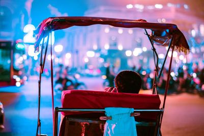 Man talking on mobile phone while sitting in cart at night