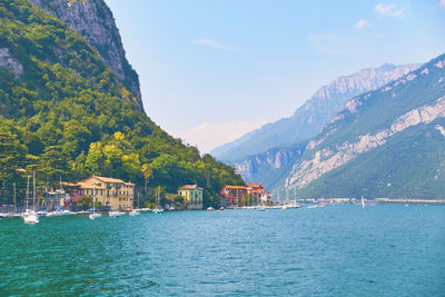 Scenic view of sea by mountains against sky