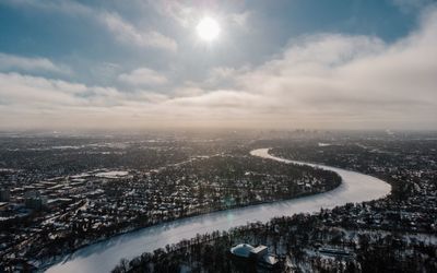 Aerial view of city buildings against cloudy sky