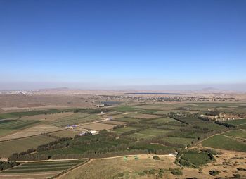 Scenic view of agricultural field against clear blue sky