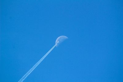 Low angle view of vapor trail against clear blue sky