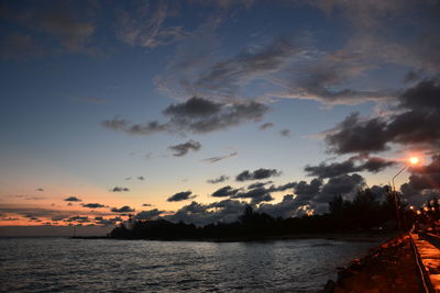 Scenic view of sea against dramatic sky during sunset