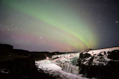 Scenic view of snowcapped mountains against sky at night