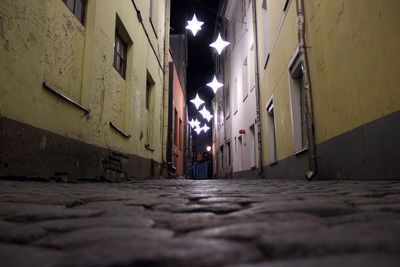 Surface level of illuminated street amidst buildings at night