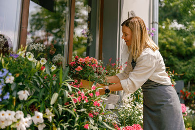 Side view of young woman holding flowers