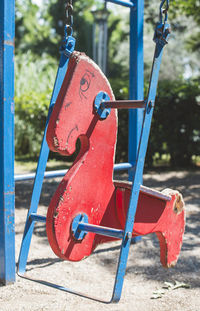 Red swing hanging in park