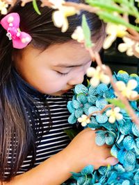 Close-up of girl smelling blue flowers blooming outdoors