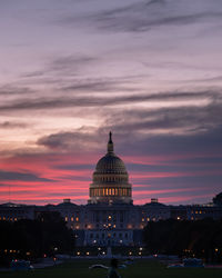 Illuminated building against cloudy sky at sunset