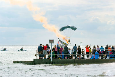 People at beach against sky