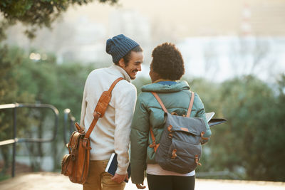 Rear view of couple walking on field