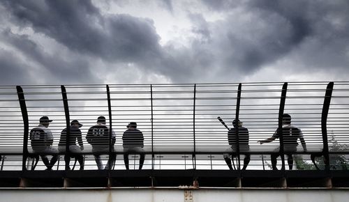 People waiting in city against sky