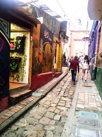 People walking on street amidst buildings in city