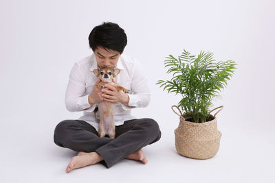 Man holding potted plant against white background