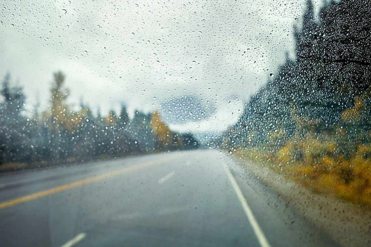 ROAD SEEN THROUGH WET CAR WINDOW