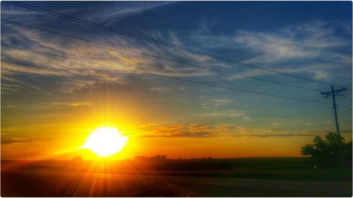 Sun shining through clouds over landscape