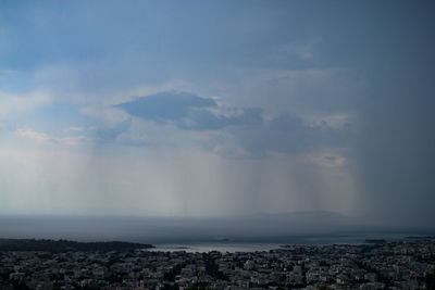 Aerial view of city by sea against sky