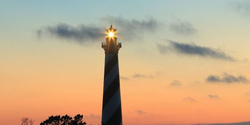 Low angle view of illuminated building against sky during sunset
