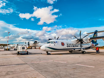 Airplane on airport runway against sky