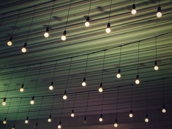 Low angle view of illuminated lights hanging on ceiling