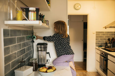 Woman touching plug in electric socket