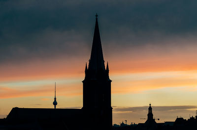 Silhouette of clock tower in city