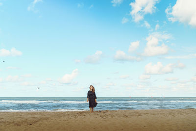 Full length of man standing on beach against sky
