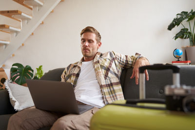 Portrait of senior man using laptop while sitting at home