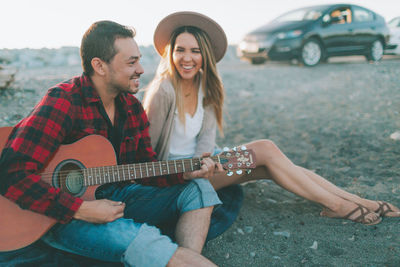 Young couple playing guitar