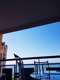 Low angle view of railing against blue sky