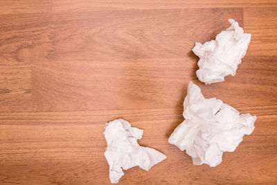 High angle view of crumpled papers on wooden table